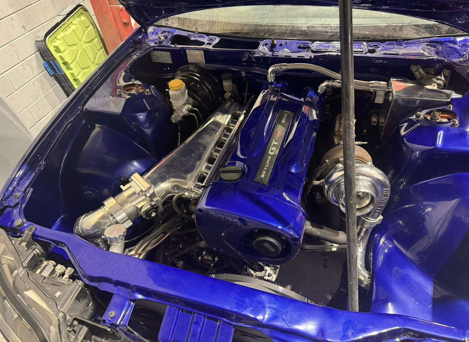 Close-up of a blue car engine with visible components.