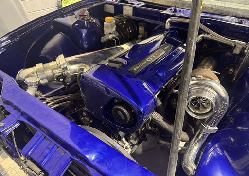 Close-up of a blue engine with visible components in an indoor setting