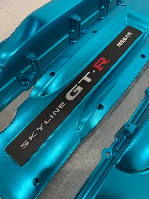Blue Nissan Skyline GT-R engine cover on a gray background